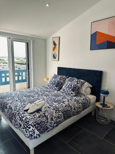 une chambre avec un lit avec une couette bleue et blanche dans l'établissement Le logis de l estuaire, à Meschers-sur-Gironde