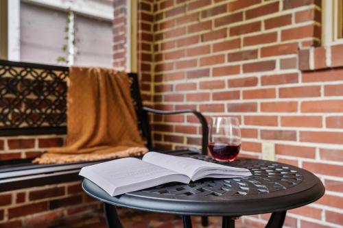 a table with an open book and a glass of wine at The Gallery at Duckpond - 1930s Historic Charm in Gainesville