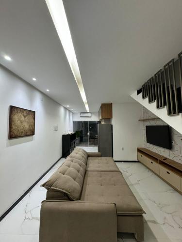 a large living room with a couch and a tv at Loftpiranahas in Piranhas