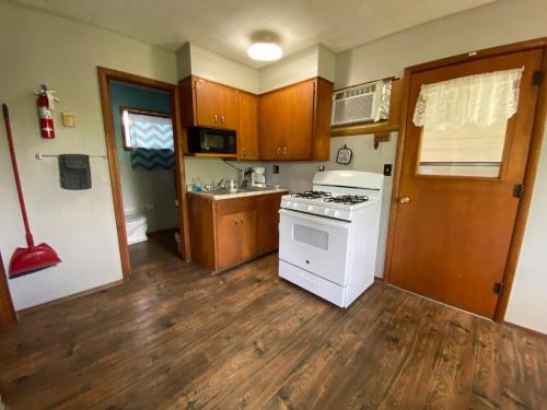 a kitchen with a white stove and wooden floors at Hickory Grove Hideaway in Galmey