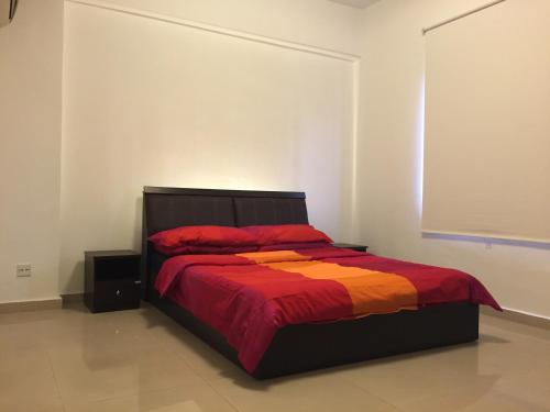 - une chambre dotée d'un lit avec une couverture rouge et orange dans l'établissement The Forum Kuala Lumpur, à Kuala Lumpur
