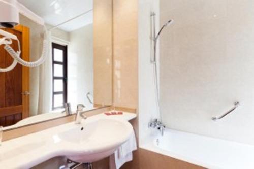 
a bathroom with a sink, mirror, and bathtub at Plaça De La Font in Tarragona
