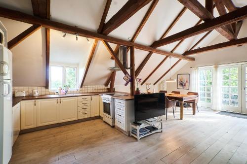 a large kitchen with wooden ceilings and a dining room at Askegaarden Apartments in Sandved