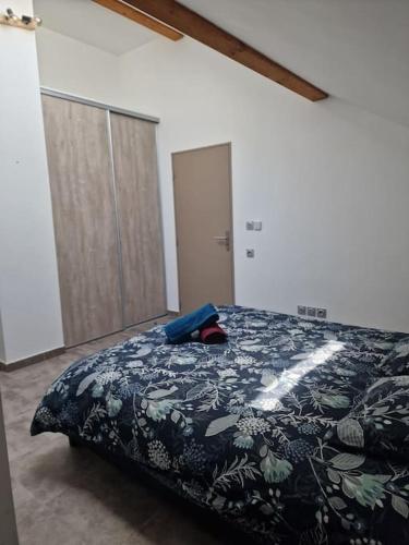 a bedroom with a bed with a black and green blanket at Superbe T2 duplex vue sur les montagnes in Chorges