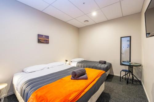 a bedroom with two beds and a television in it at Rock Solid Backpackers Rotorua in Rotorua