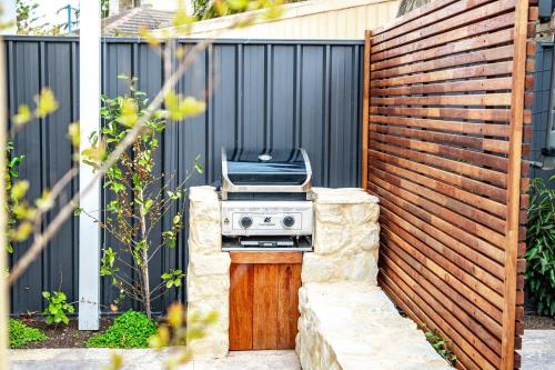 a barbecue grill in front of a fence at Horseshoe View 1A Scrymgour Rd Port Elliot - No Linen Included in Port Elliot