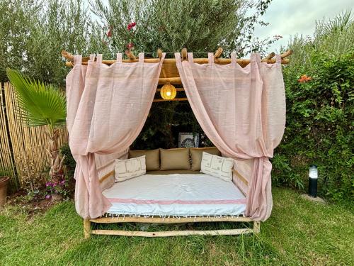 a bed in a garden with a canopy at Private Villa BSF - Hot Pool & Spa - Palm Golf in Marrakech