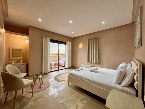 a bedroom with a bed and a desk and a window at Private Villa BSF - Hot Pool & Spa - Palm Golf in Marrakech