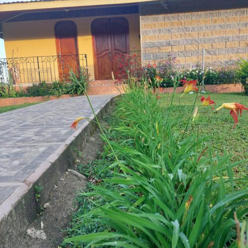 a garden with flowers in front of a house at Villa Esperanza El Castillo in Fortuna