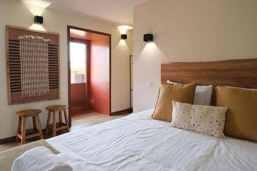 a bedroom with a large white bed with pillows at JADS Guesthouse in Fafião