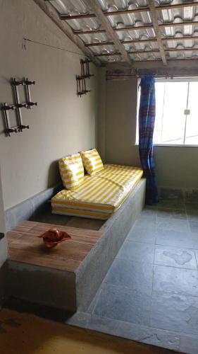 a bed sitting inside of a room with a window at Hostel Recanto in Saquarema