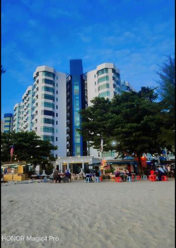 a group of tall buildings on a beach with trees at Mutiara Melaka Beach Resort Condominium,Pantai Puteri Melaka in Melaka