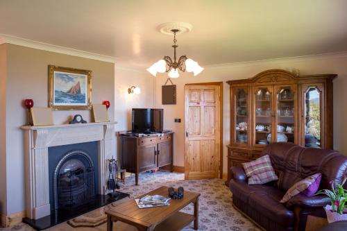 a living room with a couch and a fireplace at Killary Vista in Renvyle