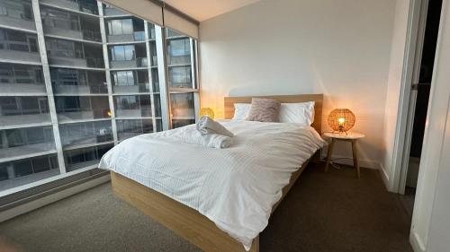 a bedroom with a bed and a large window at Nest Apartments on Rose Lane in Melbourne