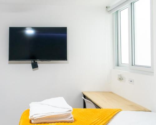 a room with a flat screen tv on a wall at Comfortable and Beautiful Room 5 minutes from Tikal Futura H3 in Guatemala