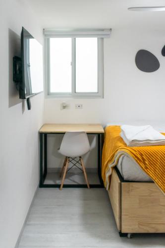 a bedroom with a desk and a bed at Comfortable and Beautiful Room 5 minutes from Tikal Futura H3 in Guatemala