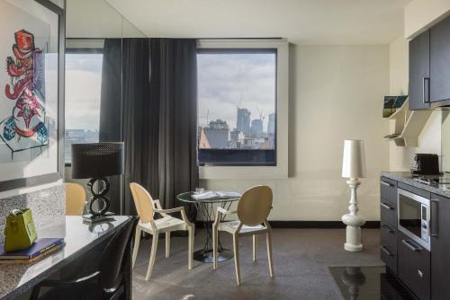 a kitchen with chairs and a table and a window at The Cullen Melbourne - Art Series in Melbourne