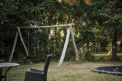 a swing set in a park with a table and chairs at Askegaarden Apartments in Sandved