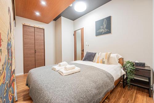 a bedroom with a bed with two towels on it at Ueno Park Asakusa Temple Ueno Family Inn in Tokyo