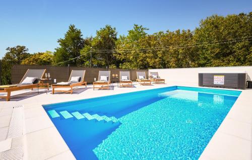 a swimming pool with chairs and a table at Cozy Home In Gornja Stubica With Sauna in Gornja Stubica