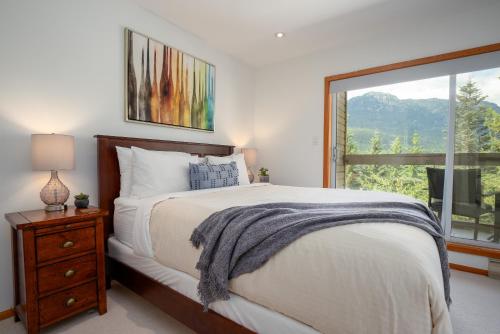 a bedroom with a large bed and a window at Ski In Ski Out 3BR Townhome in Creekside by Harmony Whistler in Whistler