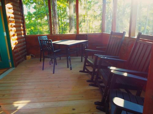a porch with tables and chairs in a cabin at The Timber Cabin in Marshall