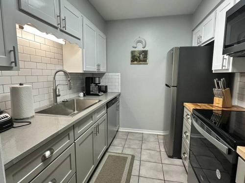 a kitchen with a sink and a refrigerator at Life is Suite at the Forester in Daphne
