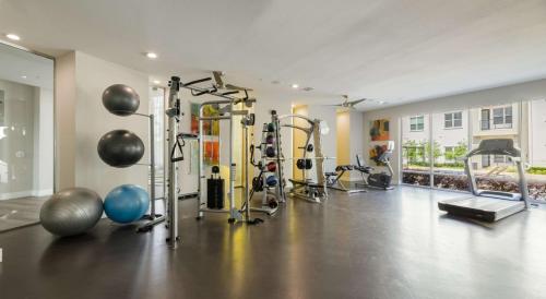 a gym with several machines and weights in a room at Tasteful 2BR I Pool I Gym I Parking I Workspace in Dallas