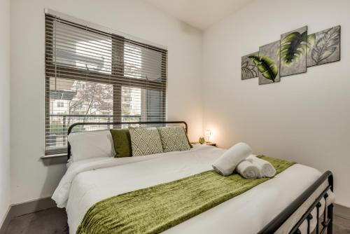 a bedroom with a large white bed with a window at Tasteful 2BR I Pool I Gym I Parking I Workspace in Dallas