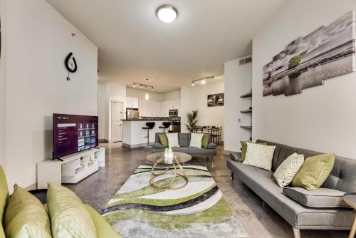 a living room with two couches and a tv at Tasteful 2BR I Pool I Gym I Parking I Workspace in Dallas