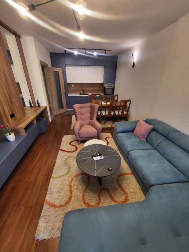 a living room with a blue couch and a table at Master apartment in Kruševac