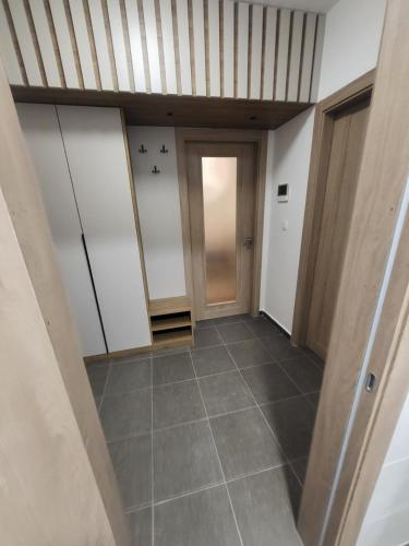 a hallway with white doors and a tile floor at Master apartment in Kruševac
