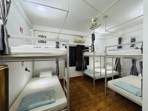 a room with three bunk beds in it at Santara Backpackers Hostel in Vang Vieng