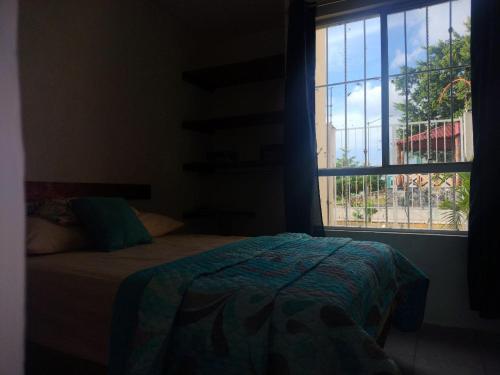a bedroom with a bed and a window at Turquoise Comfort Haven in Cancún