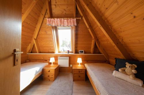 a bedroom with two beds in a wooden cabin at Ferienhaus "Nanni" Wittsand 04 in Dorum-Neufeld