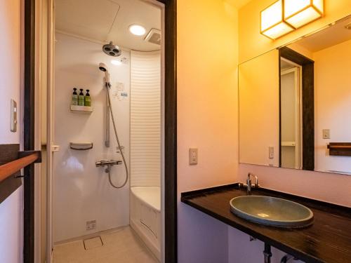 a bathroom with a sink and a toilet and a shower at Nagominoyado Hanagokoro - Reopening in Mar 2024 in Hakone