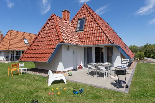 a house with an orange roof and a patio at Ferienhaus Mellumplate 37 in Dorum Neufeld