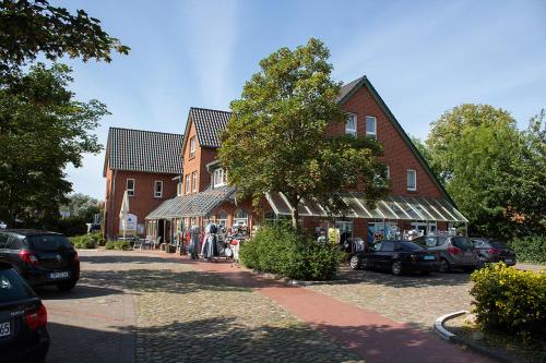 a large building with cars parked in a parking lot at Ferienhaus Mellumplate 37 in Dorum Neufeld
