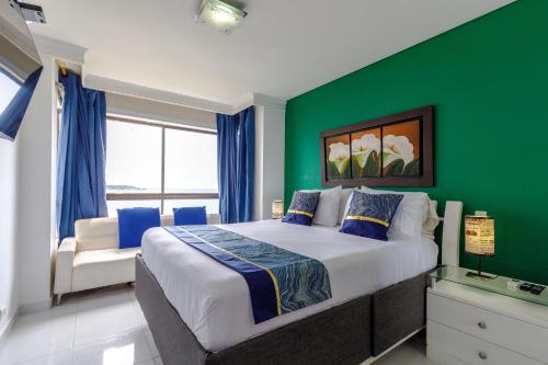 ein Schlafzimmer mit einem großen Bett und einer grünen Wand in der Unterkunft Cartagena - Torremarina in Cartagena de Indias