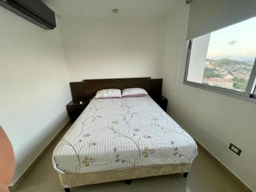 a small bedroom with a bed with a window at acogedor apartamento in Panama City