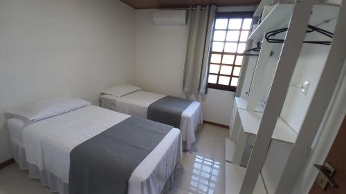 une chambre à l'hôpital avec deux lits et une fenêtre dans l'établissement Casa Ipê, à Lençóis
