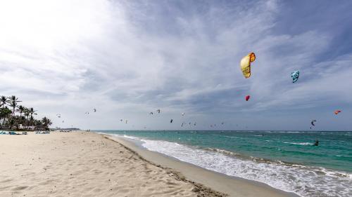 a group of kites flying over the ocean on a beach at Watermark Luxury Oceanfront Residences in Cabarete