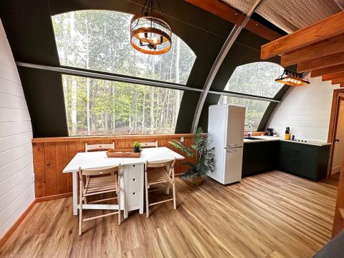 a kitchen with a table and chairs in a house at Sunken Escapes Glamping Unit 5 in New Minas