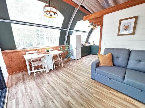 a living room with a blue couch and a table at Sunken Escapes Glamping Unit 5 in New Minas