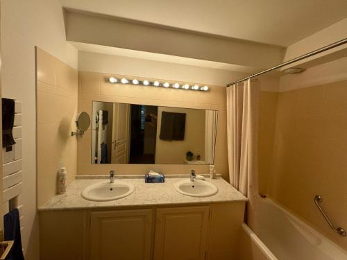 une salle de bain avec deux lavabos et un grand miroir dans l'établissement Sanary appartement 2-4 personnes à deux pas du port, à Sanary-sur-Mer