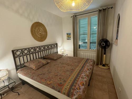 - une chambre avec un lit, un ventilateur et une fenêtre dans l'établissement Sanary appartement 2-4 personnes à deux pas du port, à Sanary-sur-Mer
