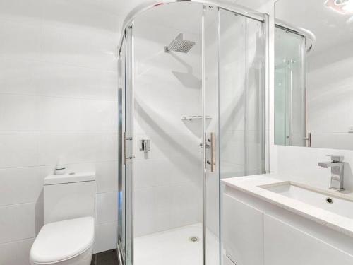 a bathroom with a shower and a toilet and a sink at Silverleaves on the Beach in Rhyll