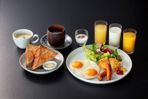 a table with a plate of breakfast foods and drinks at HOTEL AO Kanazawa in Kanazawa
