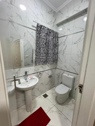 a white bathroom with a toilet and a sink at جاردن سيتى in Cairo