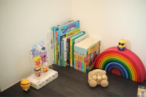 a group of books on a shelf next to a rainbow at Afiniti 2BR Sunlit Designer - 3 Min To Legoland in Iskandar Puteri